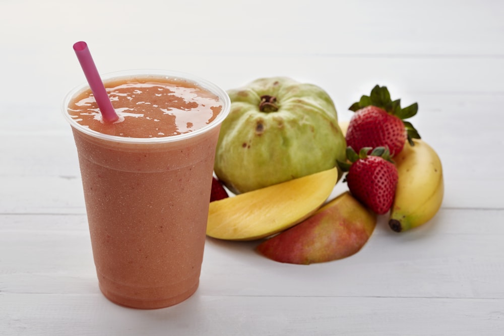 a smoothie with strawberries, apples, and bananas