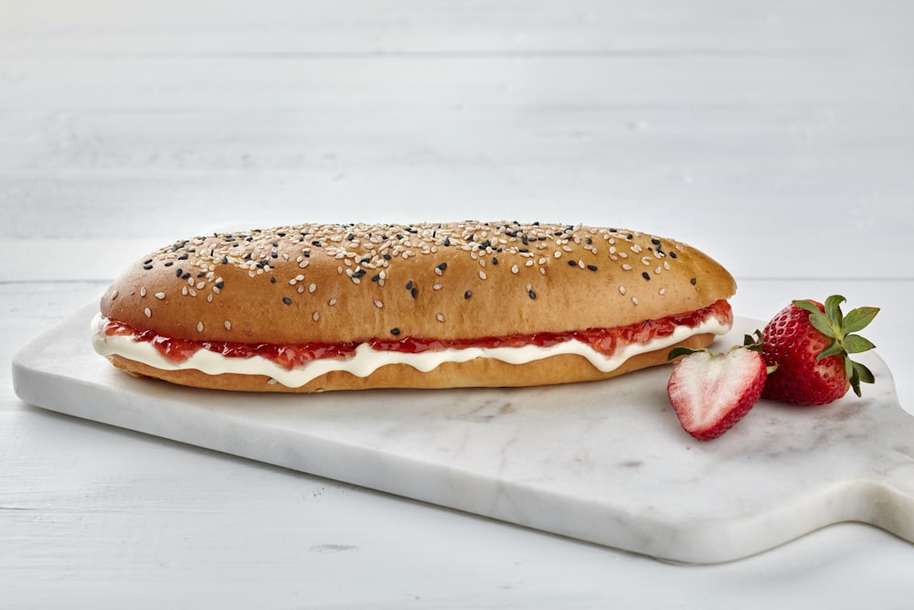 a sandwich with a strawberry on a marble platter