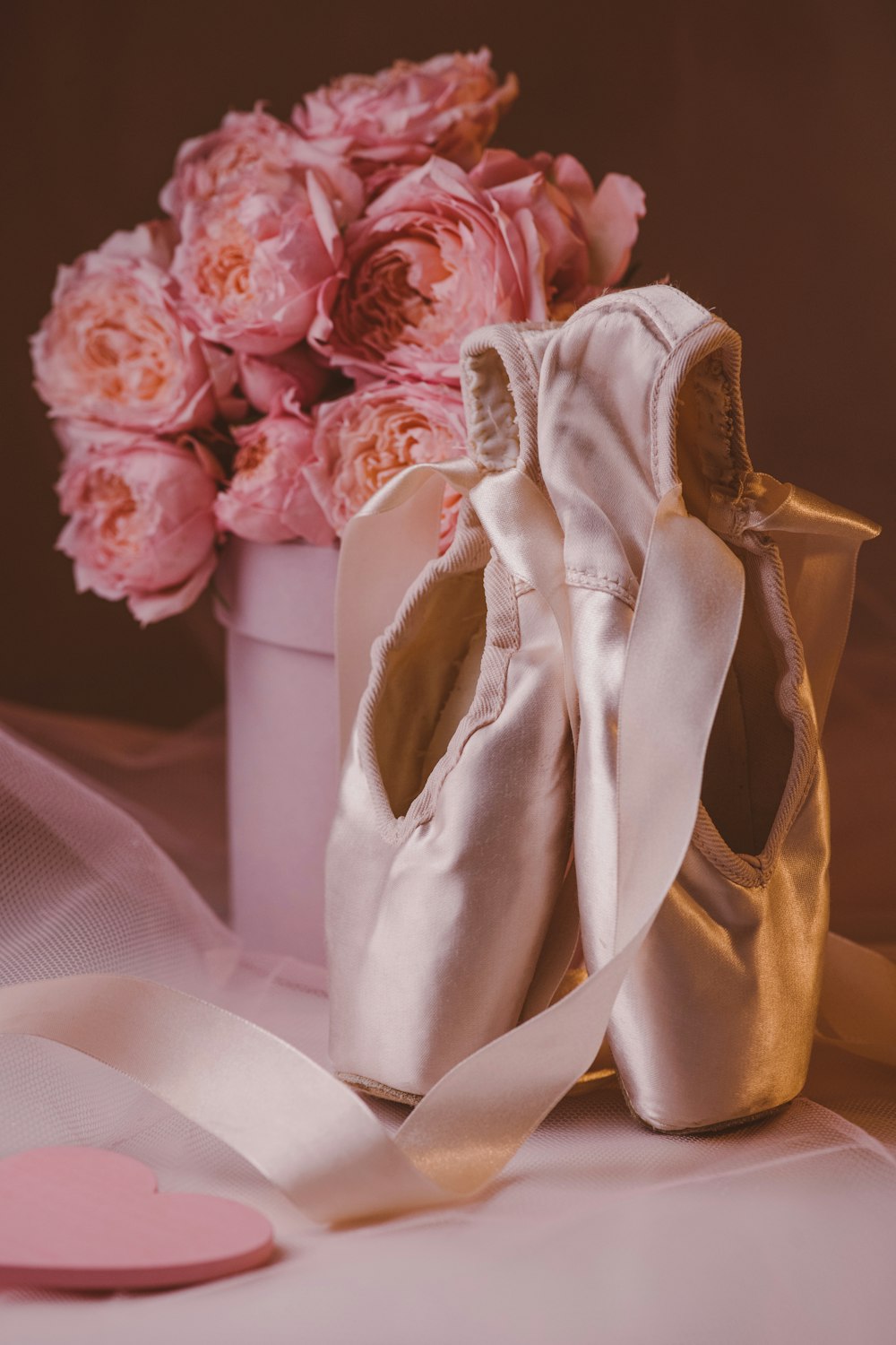 a pair of ballet shoes sitting next to a bouquet of flowers