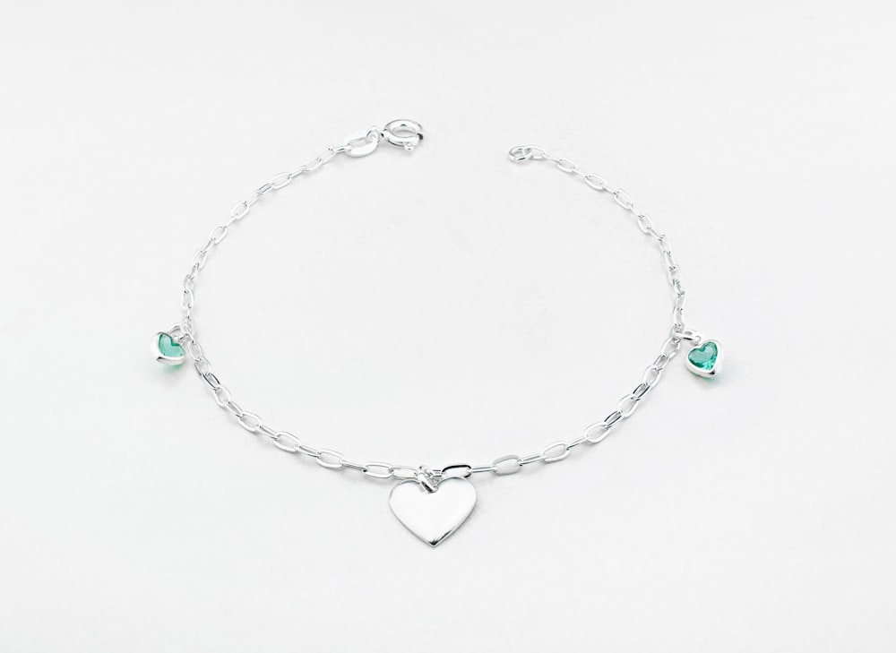 a silver bracelet with a heart charm