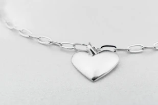 a silver heart charm on a silver chain