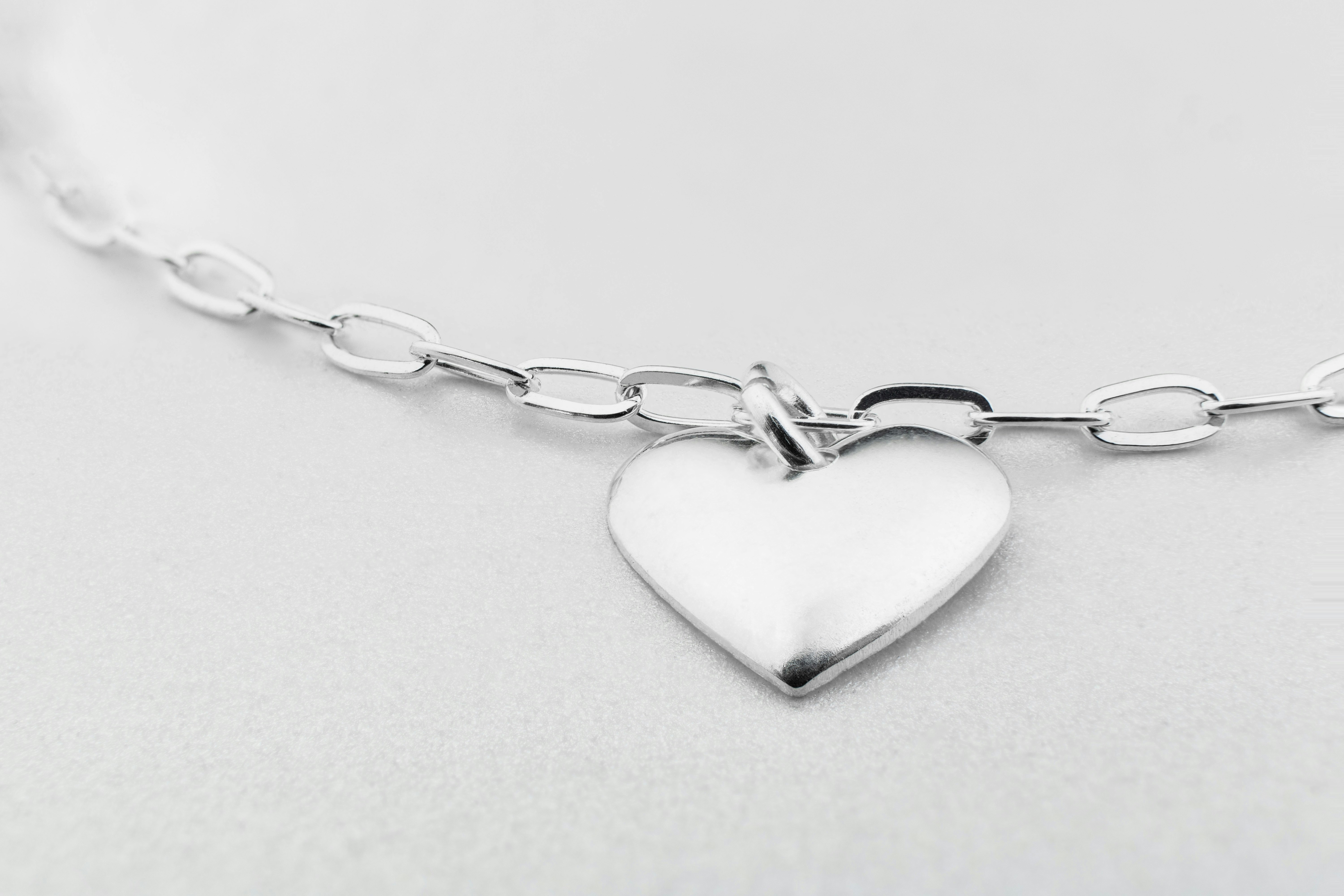 CLoseup macro shot of a silver heart-shaped piece in a silver bracelet