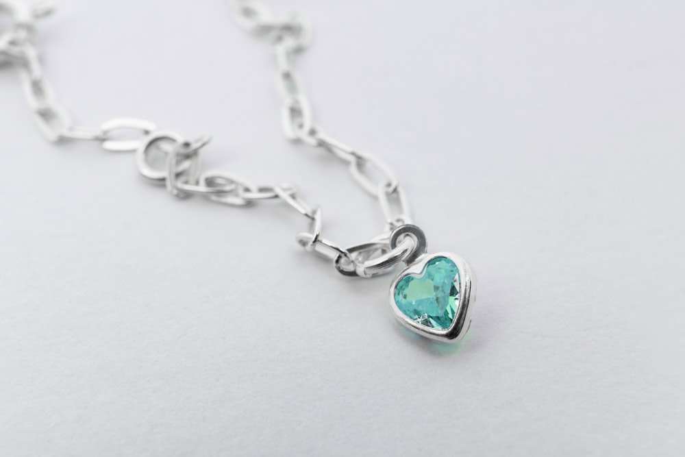 a necklace with a heart shaped pendant on a chain