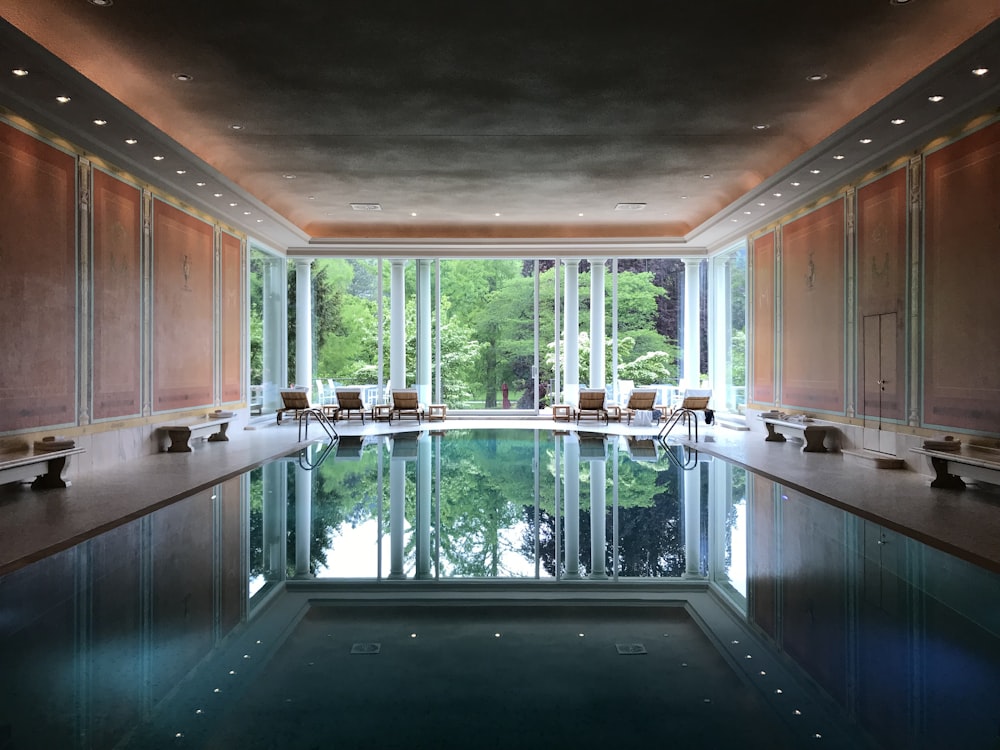 a large indoor swimming pool with a view of the trees