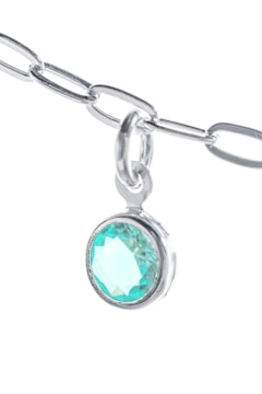 A close-up view of a silver chain with a pendant featuring a round, turquoise-colored gemstone. The chain and pendant are set against a bright white background, highlighting the shine and intricate details of the metal links. The gemstone displays a faceted cut, reflecting light and creating a sparkling effect.