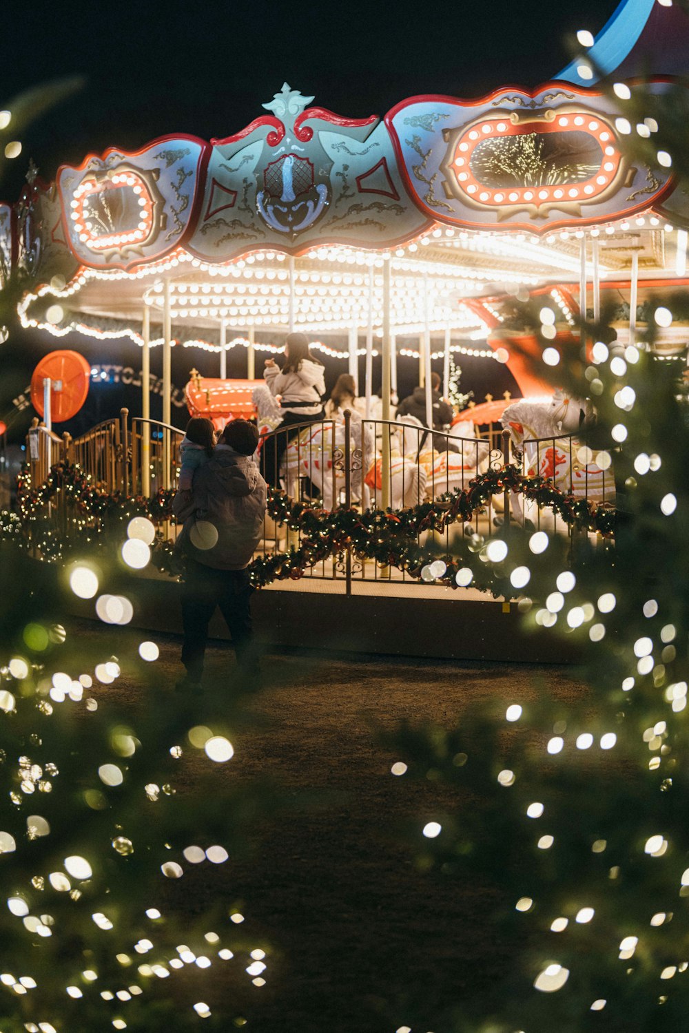a merry go round at night with people walking around