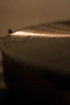 Hands holding a vinyl record with a film soundtrack label in a softly lit space