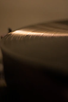 Hands holding a vinyl record with a film soundtrack label in a softly lit space