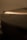 A close-up image of a vinyl record with grooves visible, softly illuminated by a warm, diffused light that casts gentle highlights across the surface.