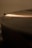A close-up image of a vinyl record with grooves visible, softly illuminated by a warm, diffused light that casts gentle highlights across the surface.