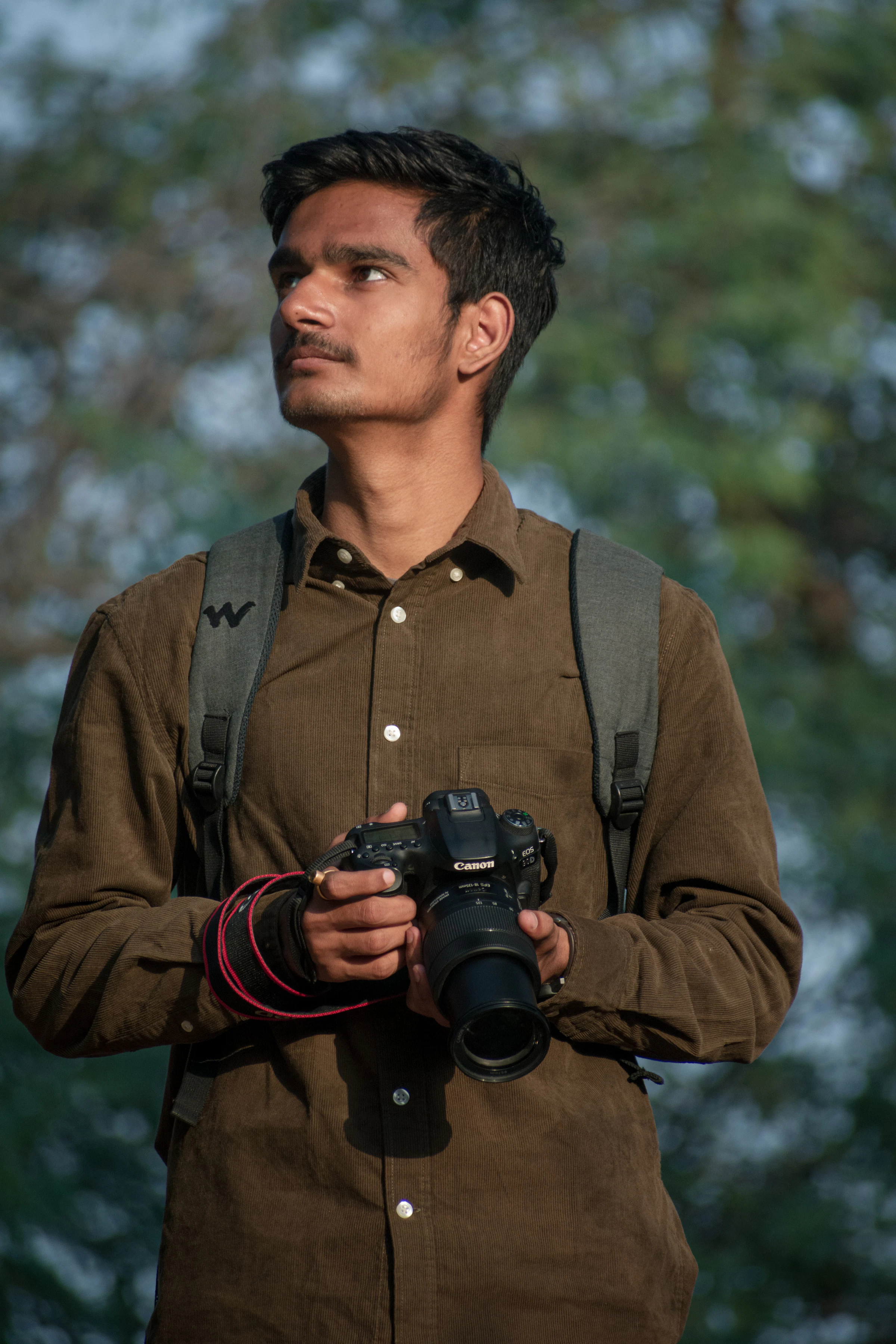 A photographer holding a professional DSLR camera, ready to shoot