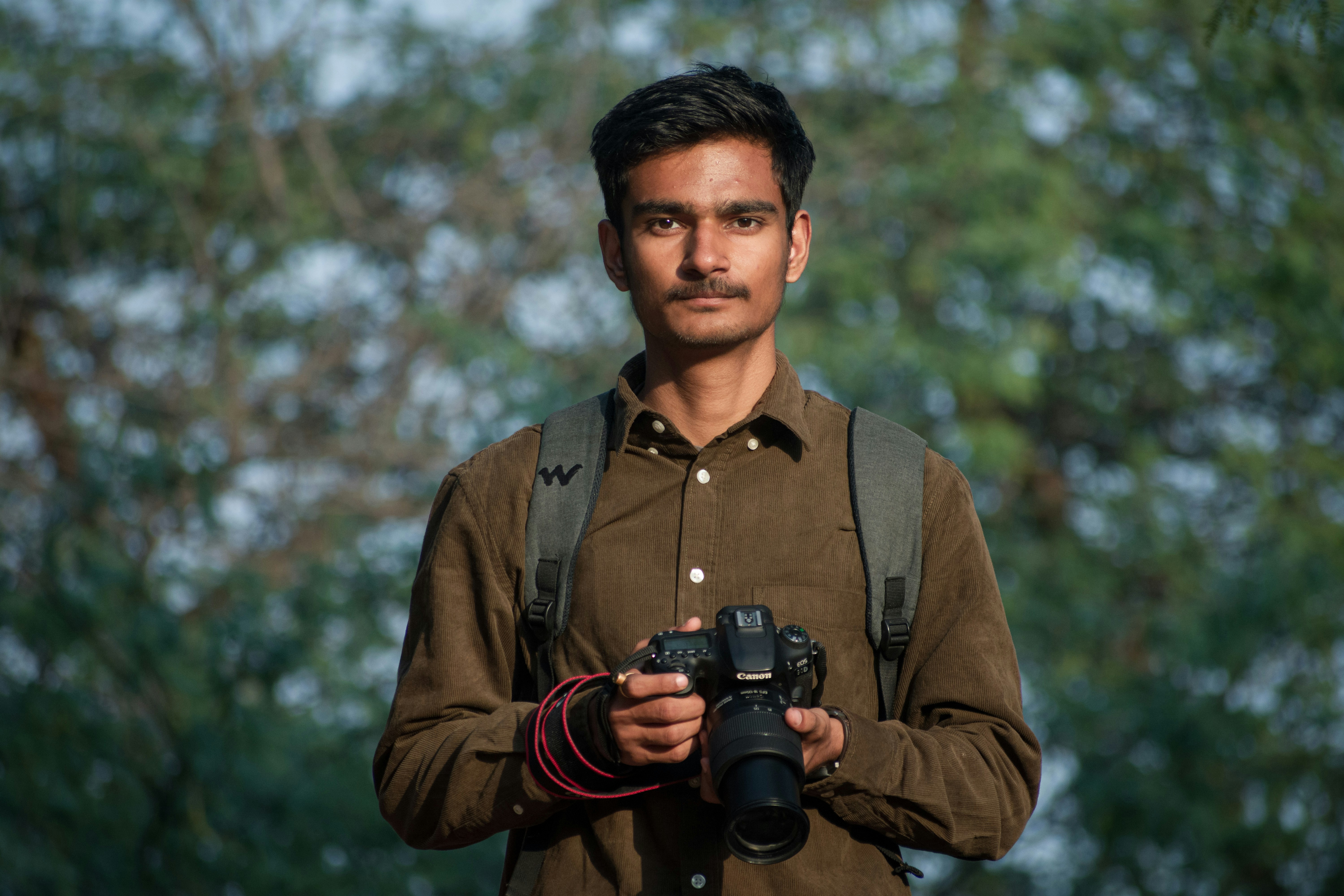 Young Indian photographer holding a professional dslr camera