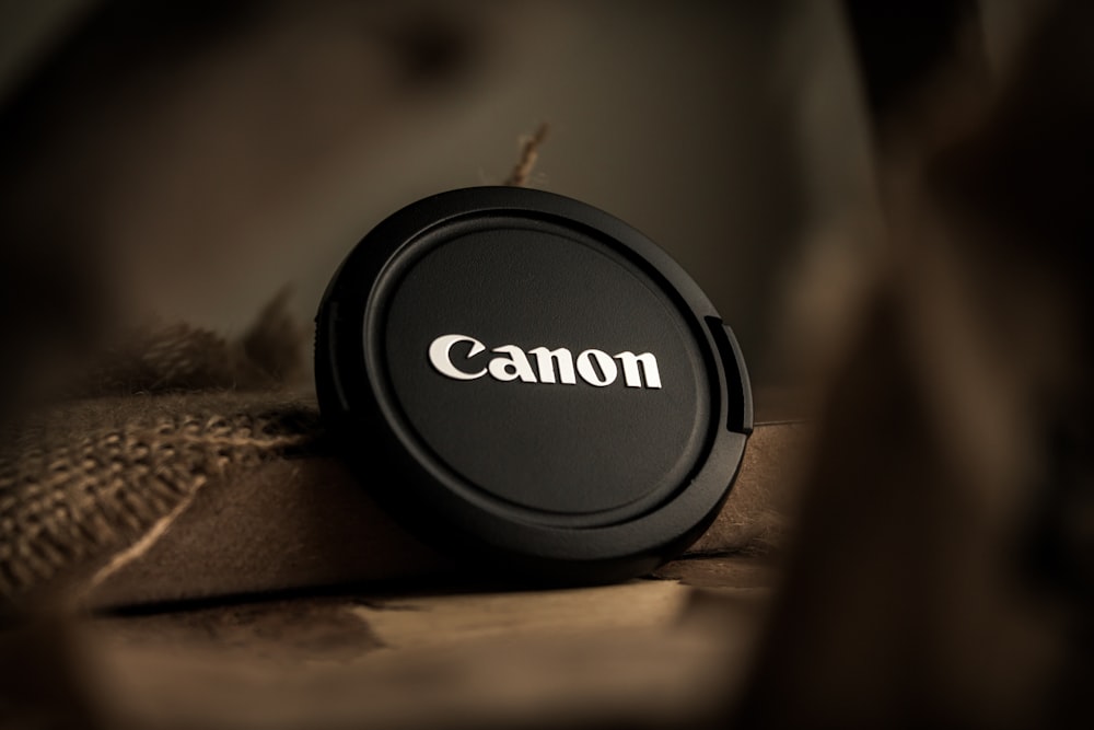 a canon lens cap sitting on top of a bag