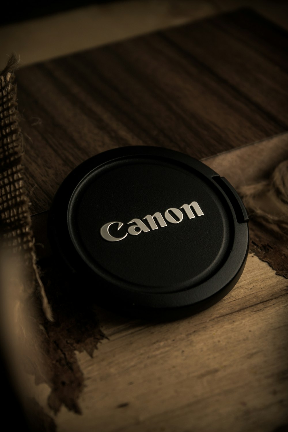 a camera lens cap sitting on top of a wooden table