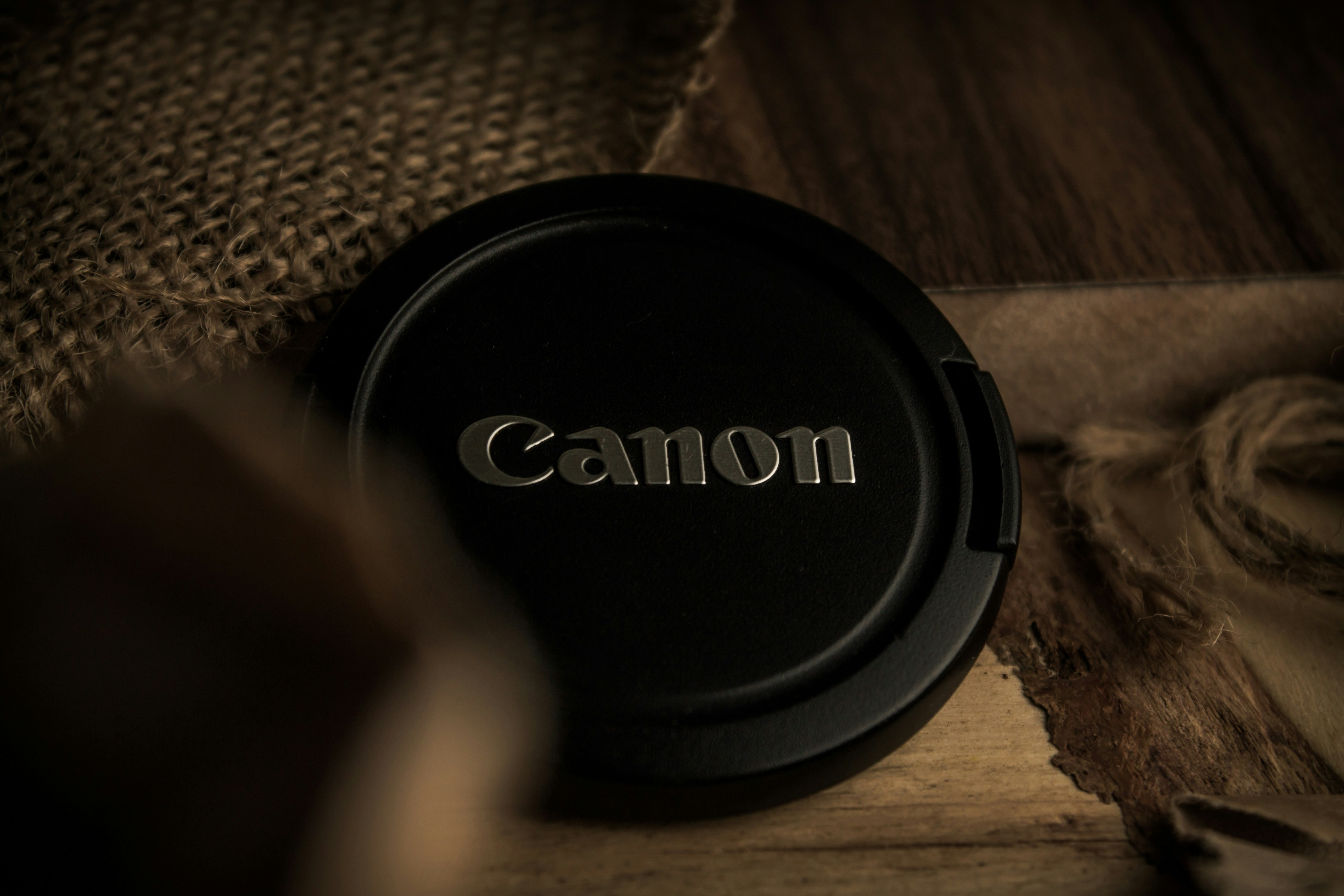 a camera lens cap sitting on top of a wooden table