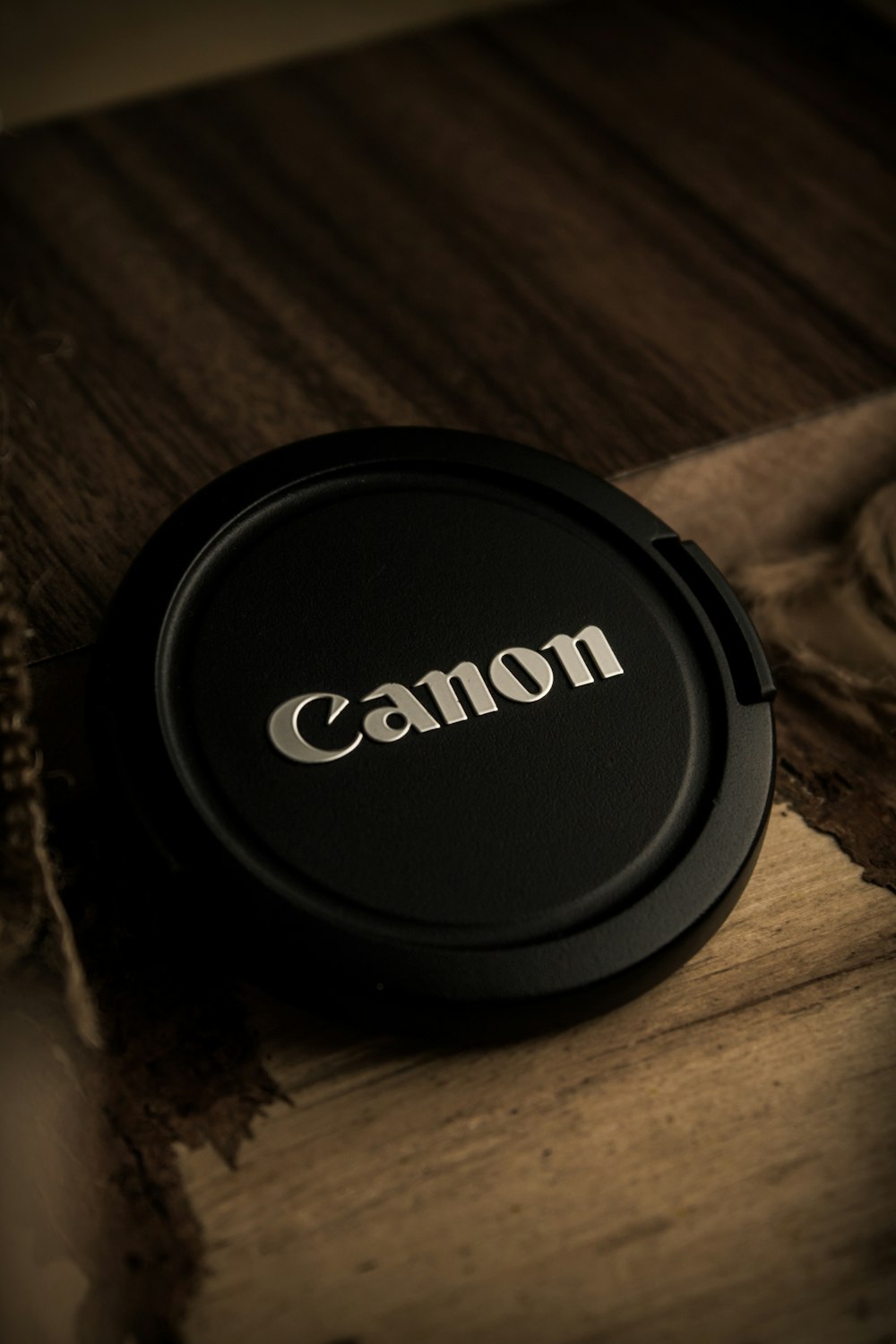 a camera lens cap sitting on top of a wooden table