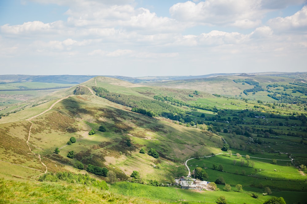 a scenic view of a green valley with rolling hills