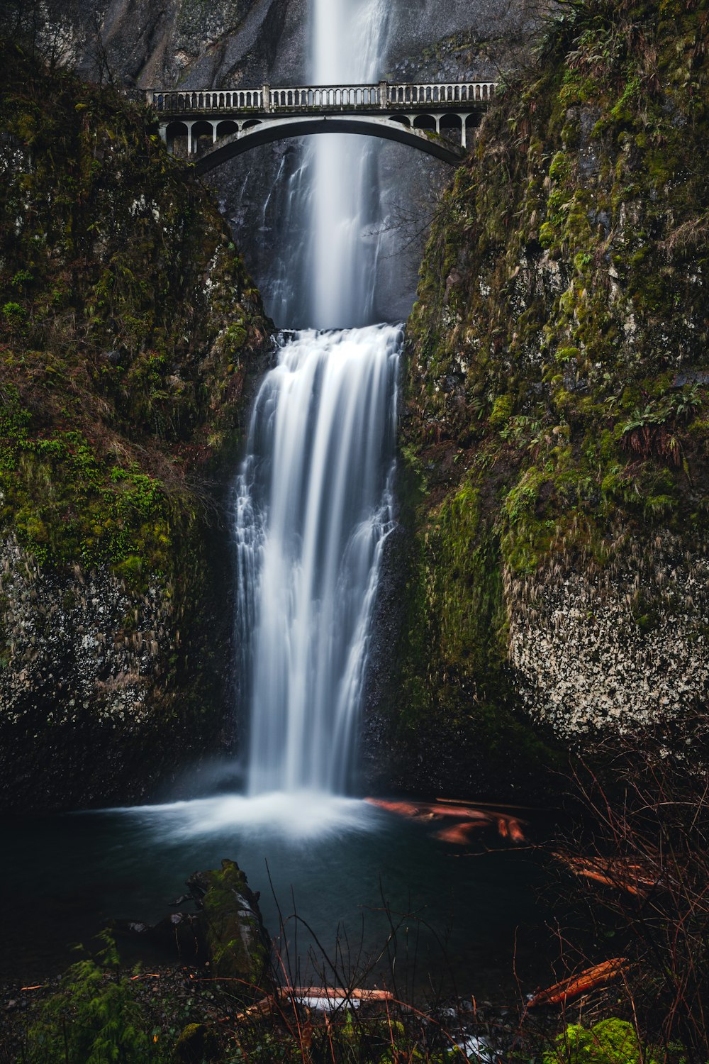 a large waterfall with a bridge over it