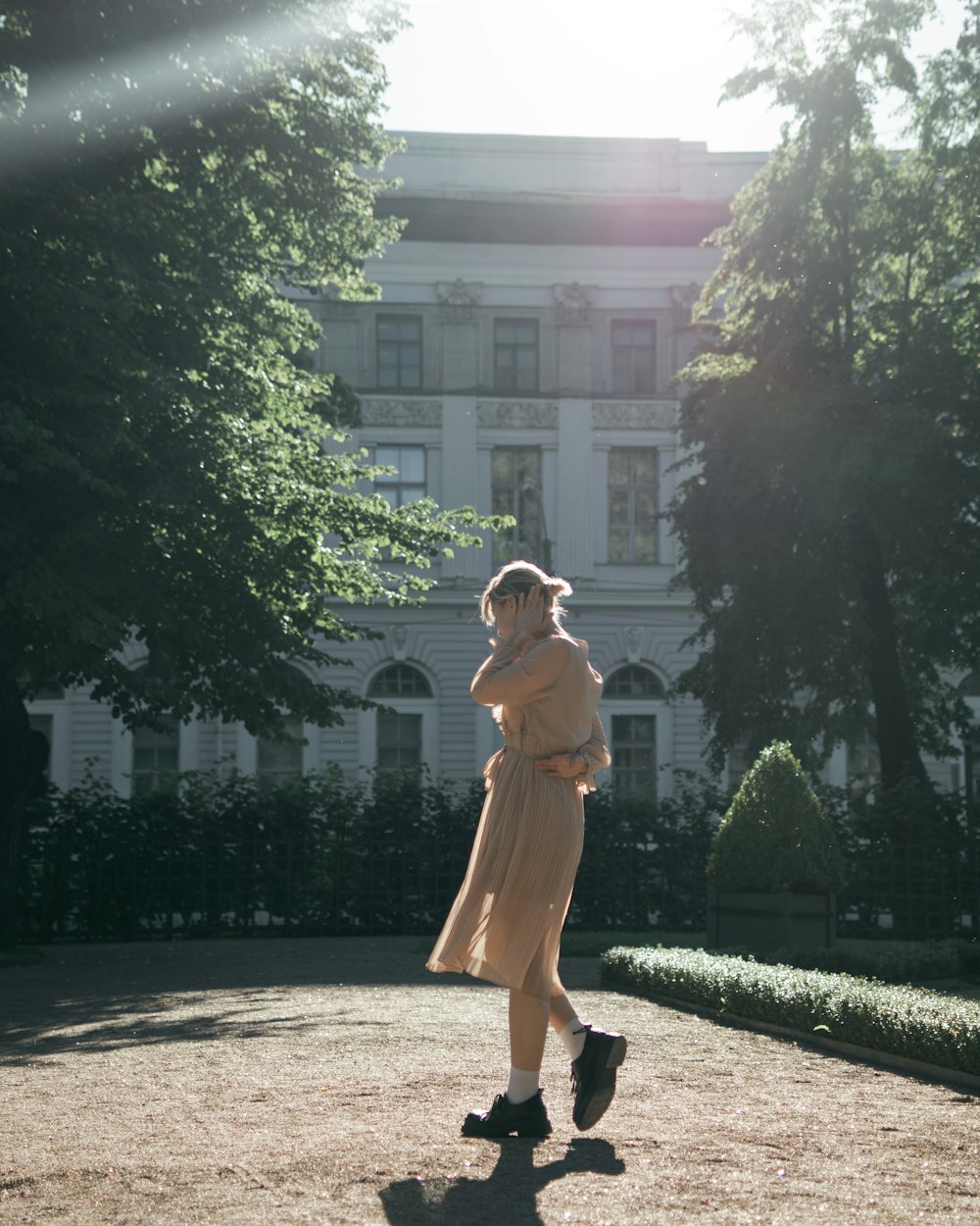 a woman in a dress standing in front of a building