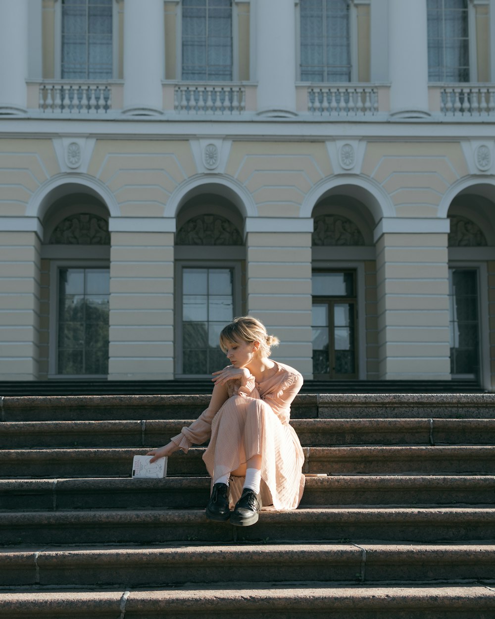 a woman sitting on steps in front of a building