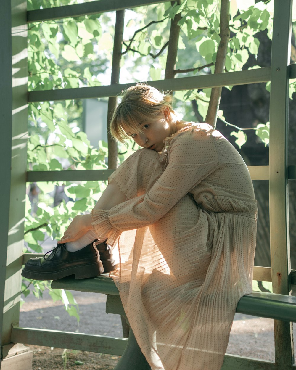 a woman sitting on a bench in a dress