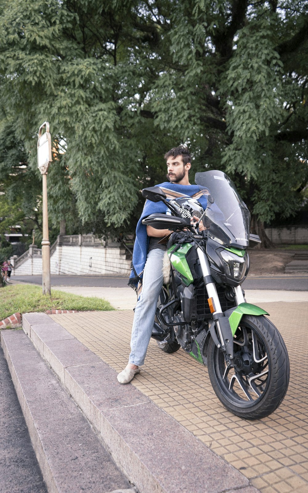 a man sitting on top of a green motorcycle