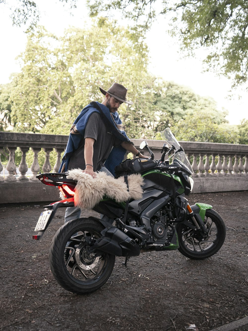 a man riding a motorcycle with a dog on the back of it