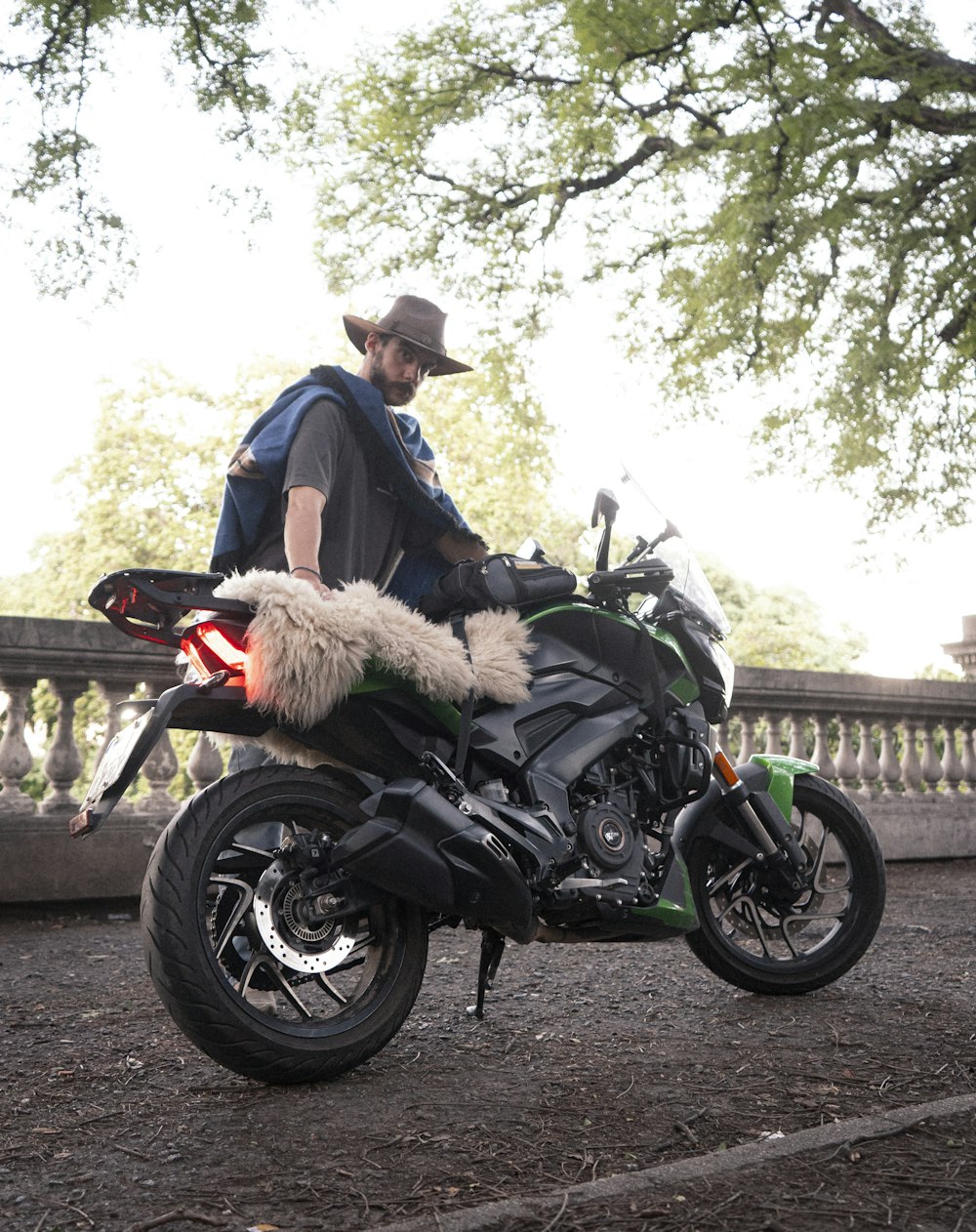 a man sitting on a motorcycle with a furry tail