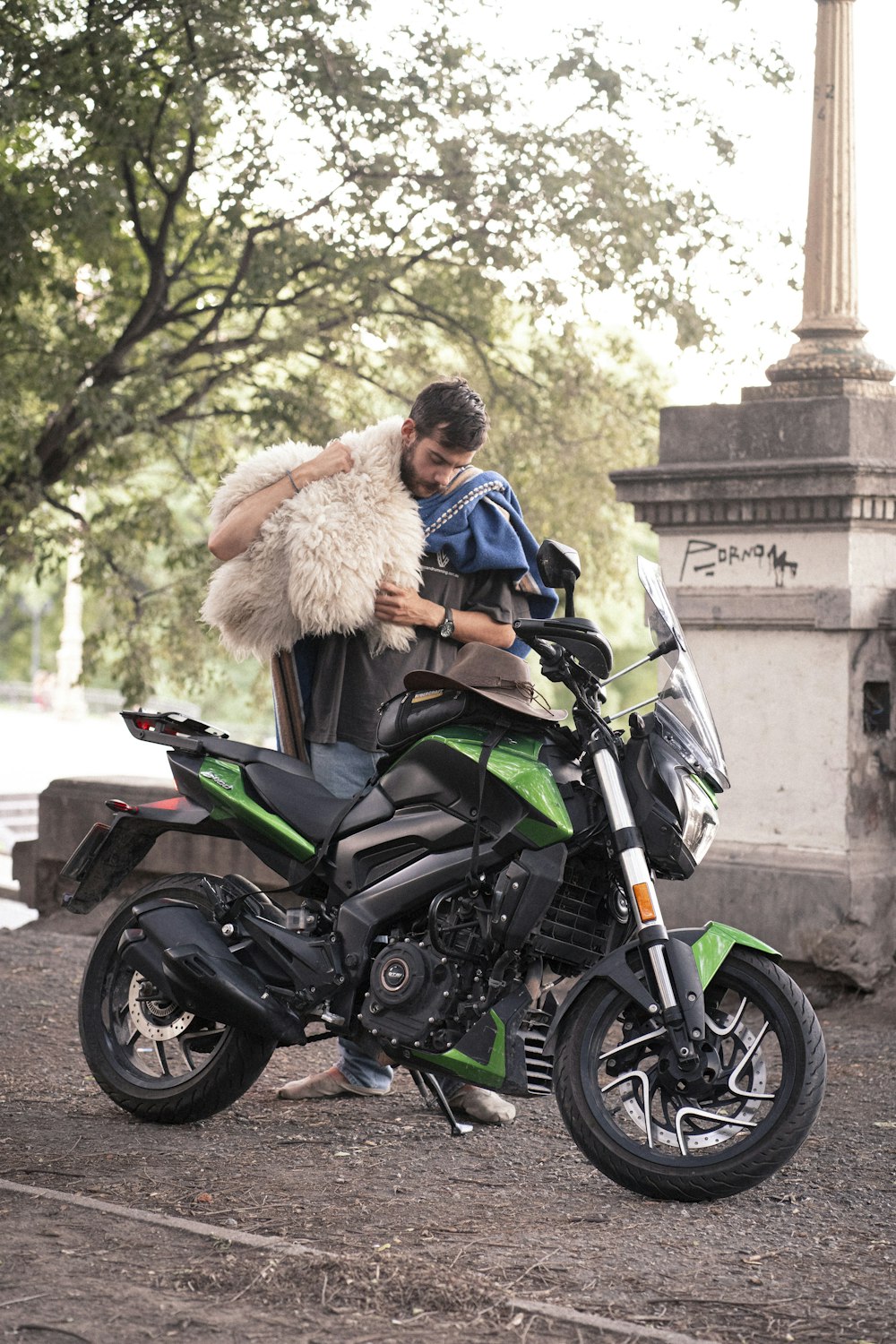 a man sitting on a motorcycle with a furry coat on