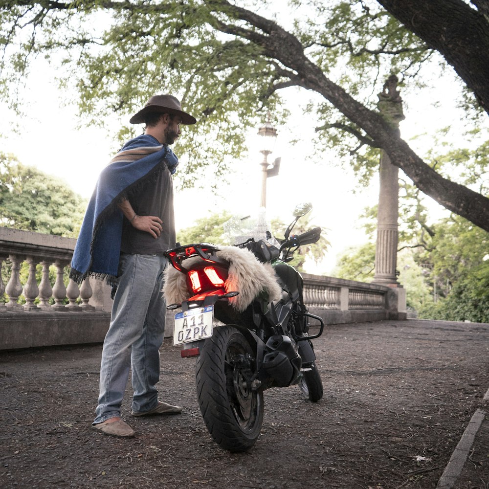 a man standing next to a parked motorcycle