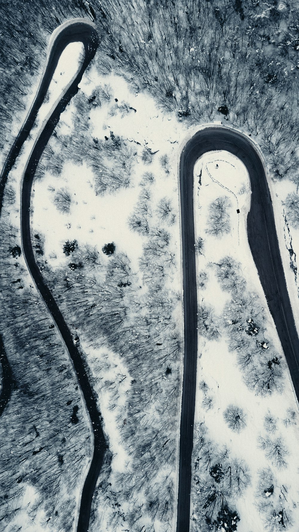 an aerial view of a winding road in the snow