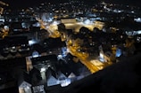 Nighttime drone shot showing illuminated streets and buildings in Ecuador