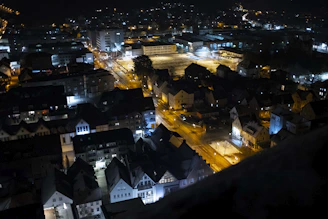 Nighttime aerial view of a thoughtfully planned city neighborhood illuminated softly.