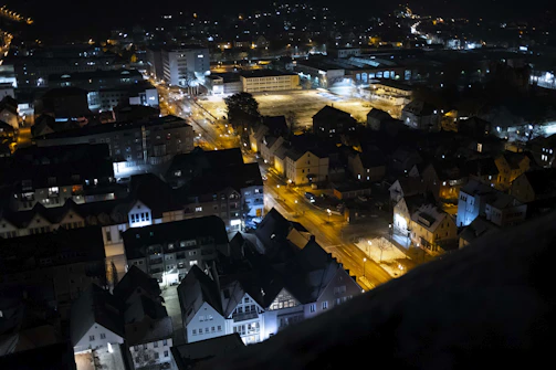 Nighttime aerial view of a thoughtfully planned city neighborhood illuminated softly.