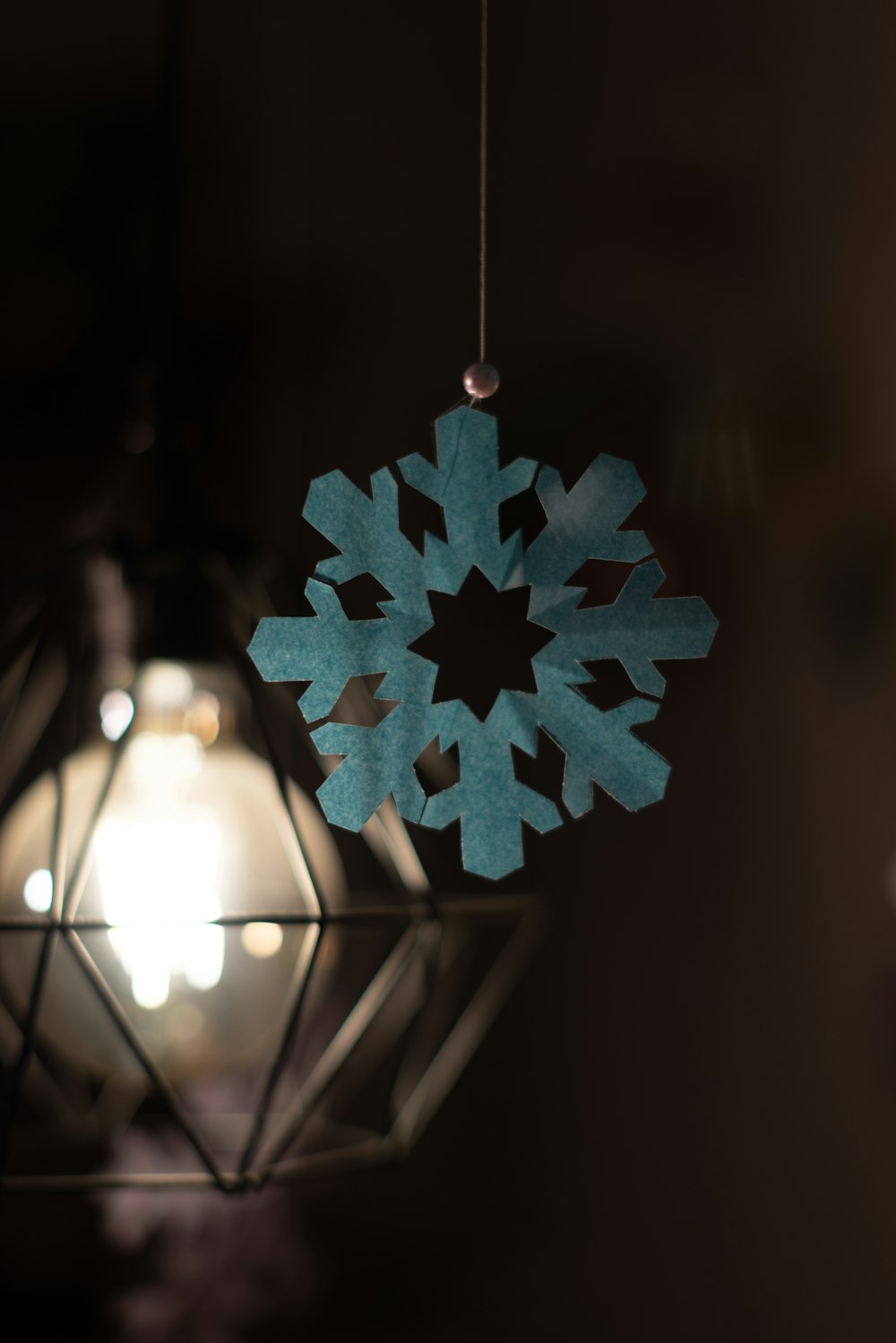 a snowflake ornament hanging from a light fixture