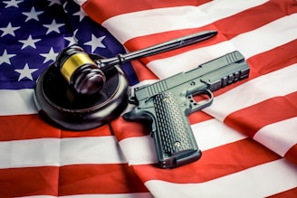 a gun, a judge's hammer, and an american flag