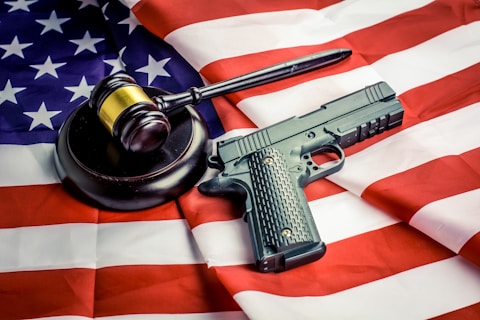 a gun, a judge's hammer, and an american flag