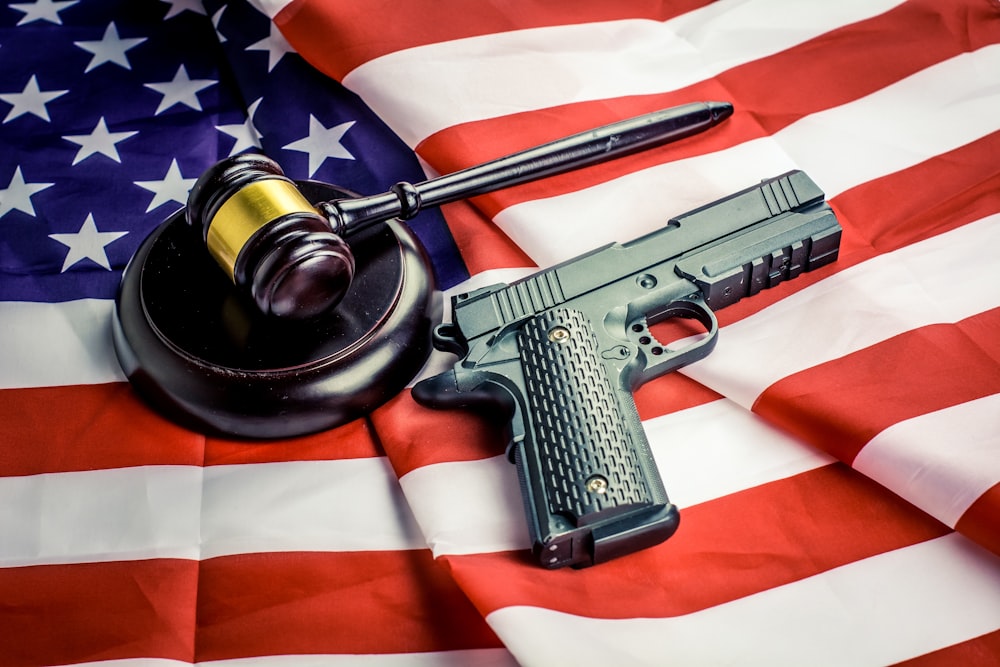 uma arma, um martelo de juiz e uma bandeira americana