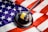 A wooden gavel with a brass band rests on a dark sound block, set against the backdrop of a United States flag. The flag features the familiar red and white stripes and white stars on a blue field, creating a strong visual association with American concepts of law and justice.