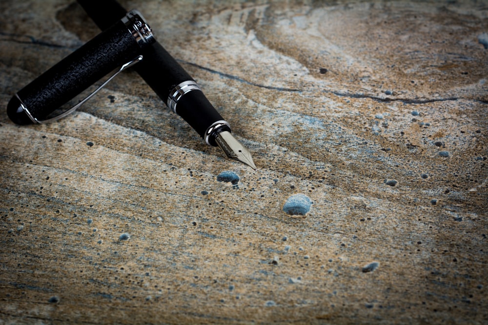a fountain pen laying on top of a rock