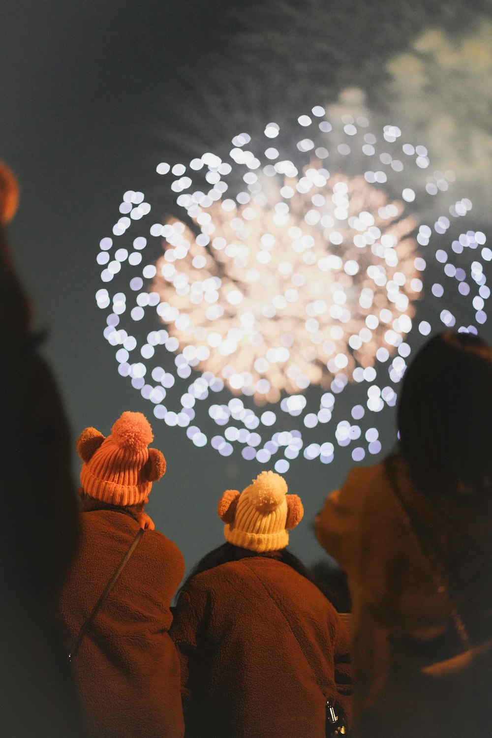 two people standing in front of a fireworks display