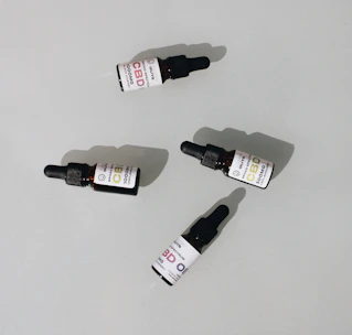 Bottles of cannabis oils and tinctures lined up with labels visible, set against a clean white backdrop.