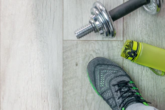 a pair of shoes and a water bottle on a wooden floor