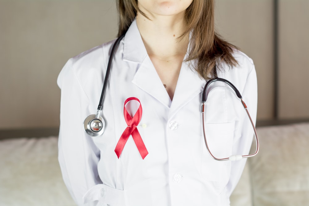une femme médecin portant un ruban rouge et un stéthoscope