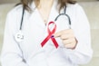 a woman in a white shirt holding a red ribbon