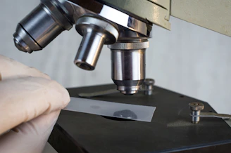 a person using a microscope to examine a piece of metal