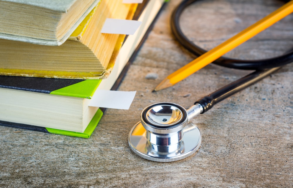 a stethoscope sitting on top of a pile of books