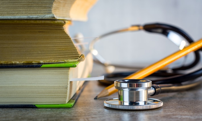 a stethoscope sitting on top of a pile of books