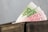 A black leather wallet with euro banknotes protruding, including denominations of 100 and 500 euros with distinctive green and pink colors.