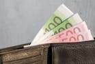a wallet with a bunch of money sticking out of it